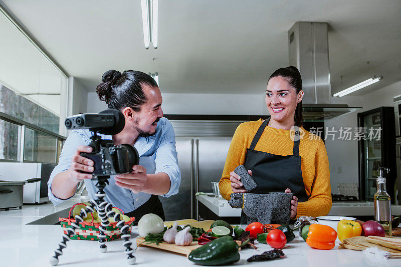 拉丁情侣blogger vlogger和网络影响者在墨西哥城的厨房录制墨西哥食物的视频内容